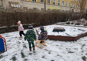 Dzieci bawiące się na śniegu.