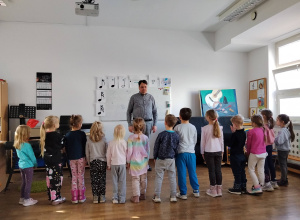 Dzieci patrzące na instruktora ustawione w rzędzie.