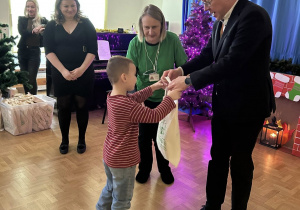 Dziecko odbierające nagrodę od Naczelnika i Dyrektora.