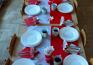 Odświętnie przyszykowany stół w biało-czerwonych kolorach.