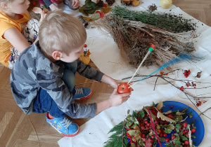 Dzieci tworzące ikebany z materiału przyrodniczego.