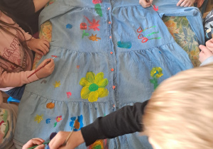 Dzieci ozdabiające sukienkę dla Marzanny.