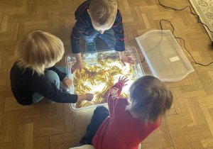 Dzieci bawiące się makaronem podświetlonym.